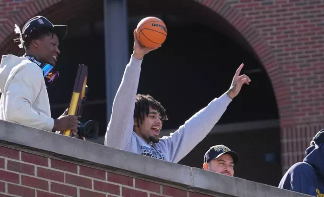 Michigan's Elliot Cadeau celebrates with fans upon returning to campus Tuesday, April 7, 2026, in Ann Arbor, Mich., the day after defeating UConn at the Final Four of the NCAA college basketball tournament. (AP Photo/Paul Sancya)