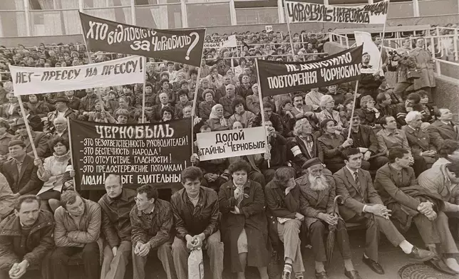 People hold signs reading "Down with the Chernobyl mysteries!" and "Who is responsible for Chernobyl?" during a protest rally demanding the truth about the Chernobyl nuclear power plant accident at a stadium in Chernobyl, Ukraine, April 26, 1989, on the third anniversary of the disaster. (AP Photo/Efrem Lukatsky)