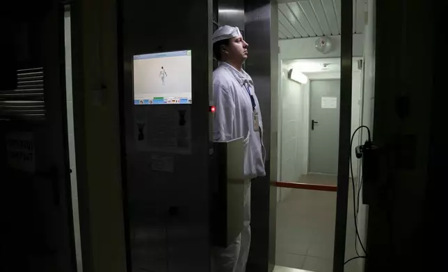 FILE - A worker checks radiation levels after leaving a nuclear waste storage site at the Chernobyl nuclear power plant in Chernobyl, Ukraine, March 23, 2016. (AP Photo/Efrem Lukatsky, File)