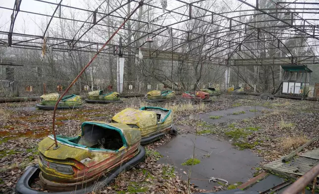 FILE - Bumper cars sit in a playground in the deserted town of Pripyat, Ukraine, Nov. 27, 2012, once home to people whose lives were connected to the nearby Chernobyl nuclear power plant. (AP Photo/Efrem Lukatsky, File)