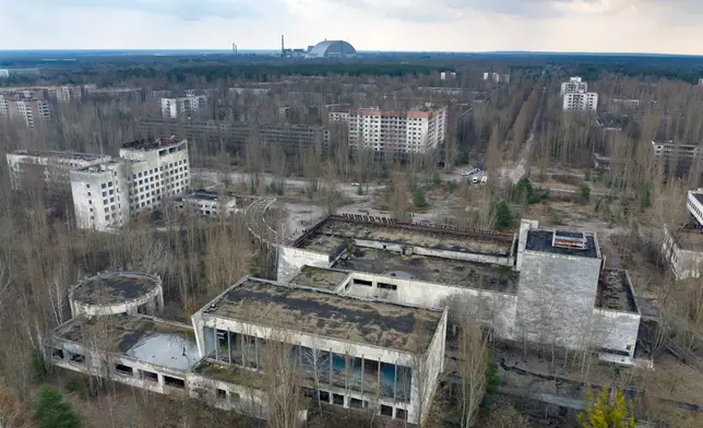 FILE - A dome-shaped shelter covering the damaged reactor at the Chernobyl nuclear plant is seen on the horizon, April 15, 2021, from the abandoned town of Pripyat, Ukraine, once home to some 50,000 people whose lives were connected to the plant. (AP Photo/Efrem Lukatsky, File)