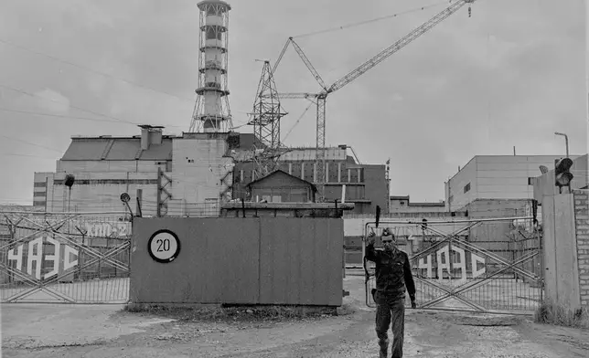 A security officer gestures to a photographer outside the gates of the Chernobyl nuclear power plant in this 1989 photo, in Chernobyl, Ukraine. (AP Photo/Efrem Lukatsky)