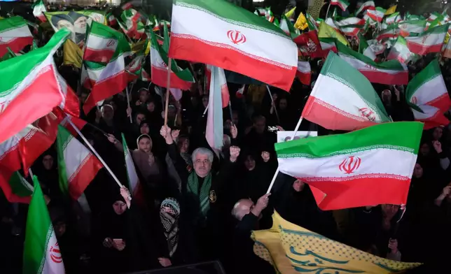 Pro-government demonstrators wave Iranian flags during a gathering in Tehran, Iran, Saturday, April 11, 2026. (AP Photo/Vahid Salemi)