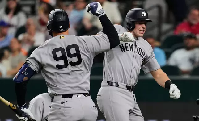New York Yankees' Aaron Judge and Ben Rice, right, celebrate Rice's two-run home run in the third inning of a baseball game against the Texas Rangers Monday, April 27, 2026, in Arlington, Texas. (AP Photo/Tony Gutierrez)