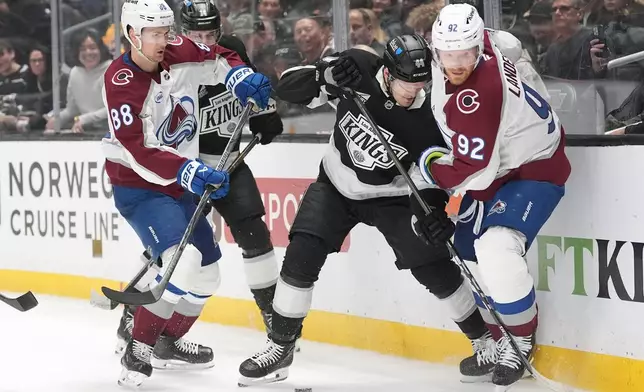 Colorado Avalanche's Gabriel Landeskog (92) and Martin Necas (88) battle Los Angeles Kings' Mikey Anderson (44) for the puck during the first period of Game 4 in the first round of an NHL hockey Stanley Cup playoff series Sunday, April 26, 2026, in Los Angeles. (AP Photo/Scott Strazzante)