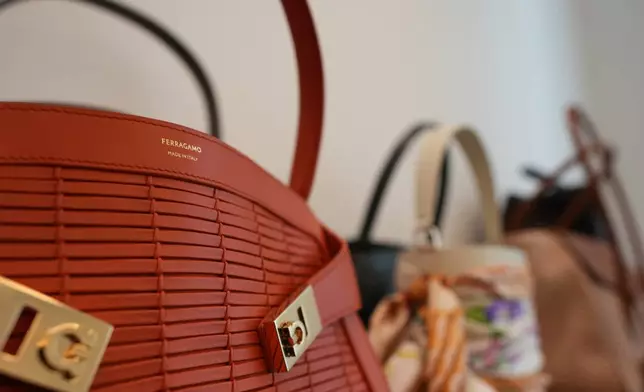 Bags are displayed as James Ferragamo, Men's and Women's Leather Product Director for the Salvatore Ferragamo group, talks during an interview with the Associated Press in Milan, Italy, Wednesday, April 22, 2026. (AP Photo/Antonio Calanni)