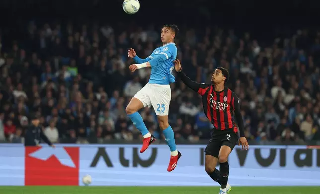 Napoli's Giovanen, left, and AC Milan's Koni De Winter battle for the ball during the Italian Serie A soccer match between Napoli and Milan in Naples, Italy, Monday, April 6, 2026. (Alessandro Garofalo/LaPresse via AP)