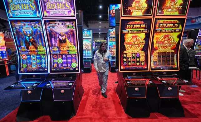 Convention attendees pass displays of gaming products and services at the Indian Gaming Association's annual convention in San Diego, Thursday, April 2, 2026. (AP Photo/Gregory Bull)