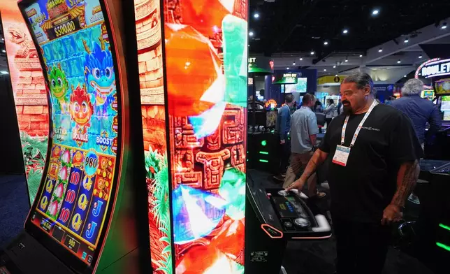 William Tucker Jr, a council member of the Sycuan Band of the Kumeyaay Nation from El Cajon, Calif., checks out a display at the Indian Gaming Association's annual convention in San Diego, Thursday, April 2, 2026. (AP Photo/Gregory Bull)