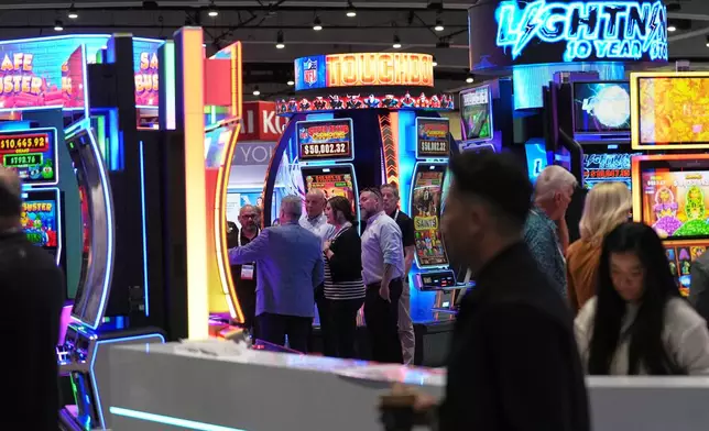 Convention attendees pass through displays of products and services for gaming at the Indian Gaming Association's annual convention in San Diego, Thursday, April 2, 2026. (AP Photo/Gregory Bull)