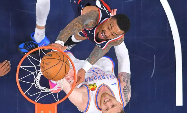 Los Angeles Clippers forward John Collins, top, shoots as Oklahoma City Thunder center Isaiah Hartenstein defends during the first half of an NBA basketball game Wednesday, April 8, 2026, in Inglewood, Calif. (AP Photo/Mark J. Terrill)