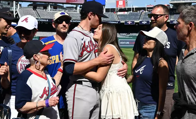 Atlanta Braves starting pitcher JR Ritchie, left center, hugs his fiancée Makena Miller after winning his major league debut baseball game against the Washington Nationals, Thursday, April 23, 2026, in Washington. (AP Photo/Nick Wass)