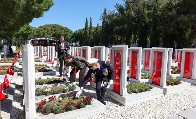 Deputy Commander of the French Strike Force Vice Admiral Yannick Bossu places red carnations at the Turkish Martyrs' cemetery after the international service in recognition of the Gallipoli campaign at Mehmetcik monument, a day before ANZAC Day, in the Gallipoli peninsula near Canakkale, Turkey, Friday, April 24, 2026. (Sercan Ozkurnazli/Dia Photo via AP)