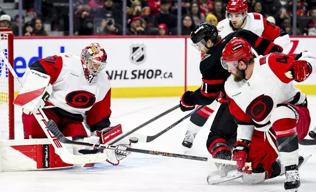 Ottawa Senators' Ridly Greig (71) tries to play the puck in the air in front of Carolina Hurricanes' goaltender Frederik Andersen (31) during the second period of an NHL hockey game in Ottawa, Ontario, on Sunday, April 5, 2026. (Spencer Colby/The Canadian Press via AP)