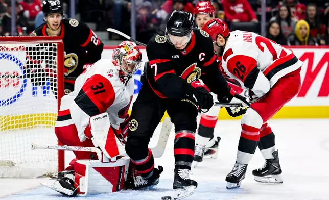 Ottawa Senators' Brady Tkachuk (7) tries to the play the puck off his skate in front of Carolina Hurricanes' goaltender Frederik Andersen (31) during the second period of an NHL hockey game in Ottawa, Ontario, on Sunday, April 5, 2026. (Spencer Colby/The Canadian Press via AP)