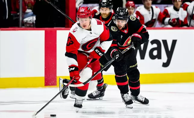 Ottawa Senators' Drake Batherson (19) defends against Carolina Hurricanes' Jackson Blake (53) as he carries the puck during first period of an NHL hockey game in Ottawa, Ontario, on Sunday, April 5, 2026. (Spencer Colby/The Canadian Press via AP)
