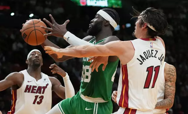 Miami Heat forward Jaime Jaquez Jr. (11) defends Boston Celtics center Neemias Queta (88) during the first half of an NBA basketball game, Wednesday, April 1, 2026, in Miami. (AP Photo/Lynne Sladky)
