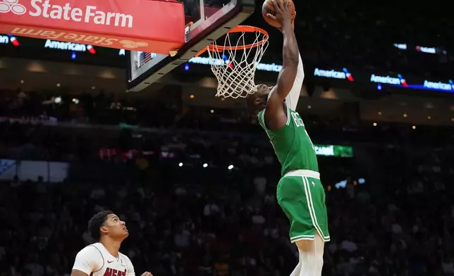 Boston Celtics guard Jaylen Brown, right, dunks over Miami Heat guard Dru Smith, left, during the first half of an NBA basketball game, Wednesday, April 1, 2026, in Miami. (AP Photo/Lynne Sladky)