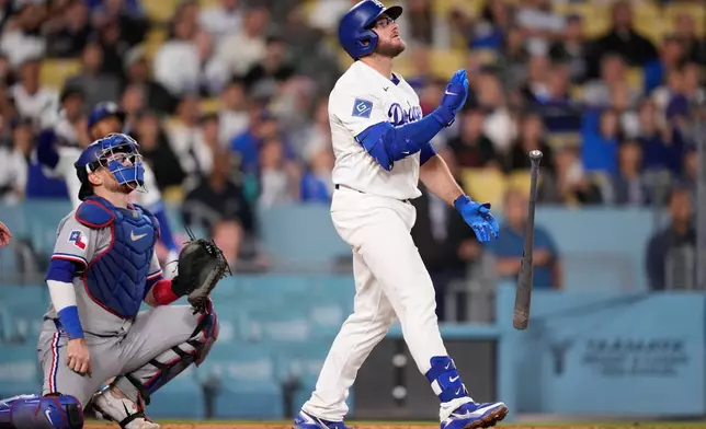 Los Angeles Dodgers third baseman Max Muncy hits a walk off solo home run as Texas Rangers catcher Danny Jansen during the ninth inning of a baseball game Friday, April 10, 2026, in Los Angeles. (AP Photo/Mark J. Terrill)