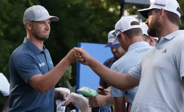 Zurich defending champion Andrew Novak, right, fist bumps Wyndham Clark before they tee off on the 10th hole to start the first round of the PGA Zurich Classic golf tournament at TPC Louisiana, Thursday, April 23, 2026, in Avondale, La. Novak is playing with Ben Griffin and Clark with Taylor Moore. (AP Photo/Matthew Hinton)