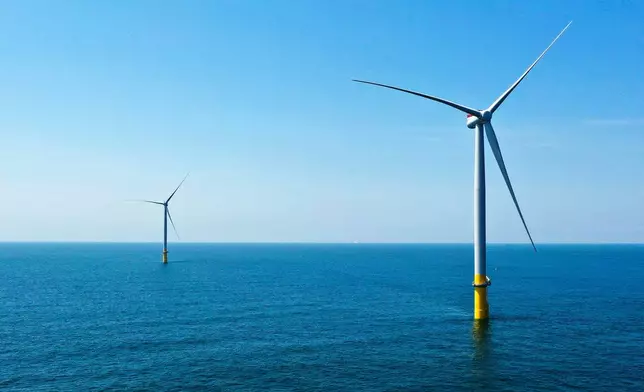 FILE - Two offshore wind turbines are seen off the coast of Virginia Beach, Va., on June 29, 2020. (AP Photo/Steve Helber, File)
