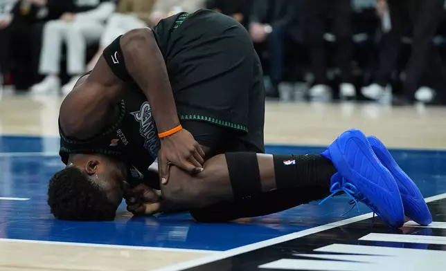 Minnesota Timberwolves guard Anthony Edwards kneels on the court after sustaining an injury during the first half of Game 4 of a first-round NBA basketball playoff series against the Denver Nuggets, Saturday, April 25, 2026, in Minneapolis. (AP Photo/Abbie Parr)