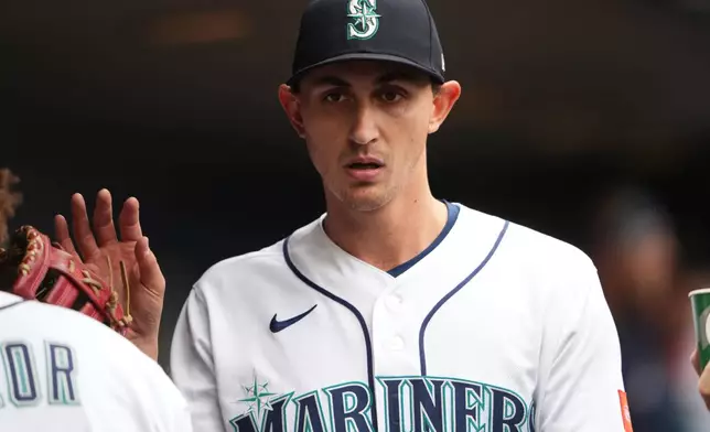 Seattle Mariners starting pitcher George Kirby greets Josh Naylor in the dugout after facing the Houston Astros during the sixth inning of a baseball game, Monday, April 13, 2026, in Seattle. (AP Photo/Lindsey Wasson)
