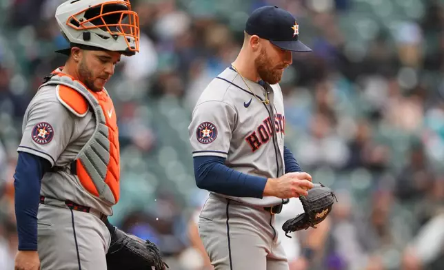 Houston Astros catcher Yainer Diaz comes to the mound to talk to starting pitcher Mike Burrows during the fifth inning of a baseball game against the Seattle Mariners, Monday, April 13, 2026, in Seattle. (AP Photo/Lindsey Wasson)