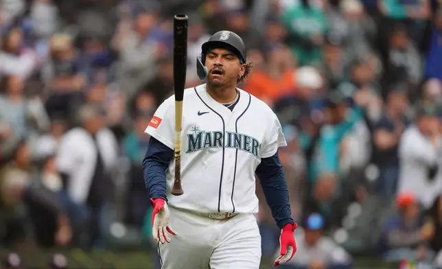Seattle Mariners' Josh Naylor flips his bat after hitting his second home run of the game, a two-run home run during the third inning of a baseball game against the Houston Astros, Monday, April 13, 2026, in Seattle. (AP Photo/Lindsey Wasson)