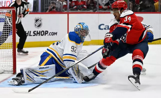 Washington Capitals center Justin Sourdif (34) reaches for a rebound off of Buffalo Sabres goaltender Colten Ellis during the first period of an NHL hockey game, Saturday, April 4, 2026, in Washington. (AP Photo/John McDonnell)