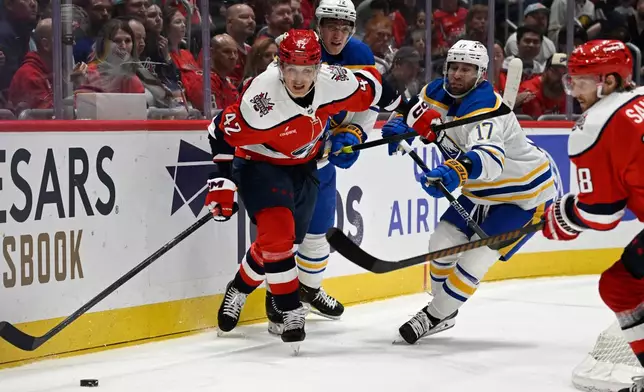Washington Capitals defenseman Martin Fehérváry (42) chats the puck against Buffalo Sabres left wing Jason Zucker (17) during the second period of an NHL Hockey game, Saturday, April 4, 2026, in Washington. (AP Photo/John McDonnell)