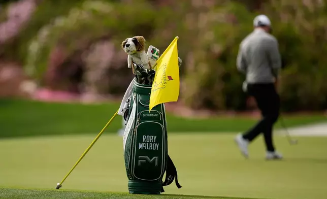 The golf bag of Rory McIlroy, of Northern Ireland, sits near the 13th hole as he putts during a practice round ahead of the Masters golf tournament at the Augusta National Golf Club, Tuesday, April 7, 2026, in Augusta, Ga. (AP Photo/Eric Gay)