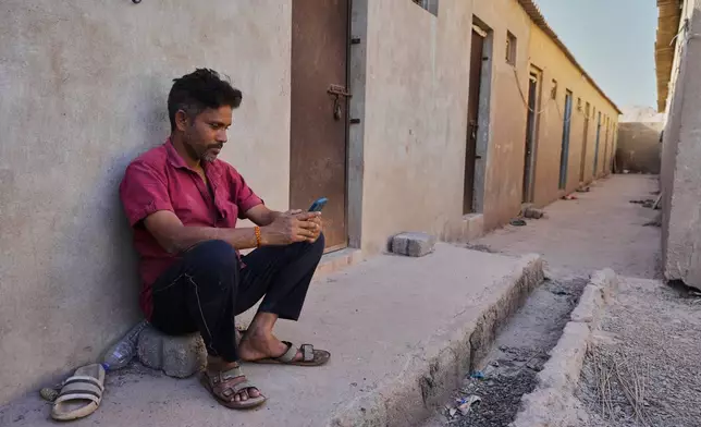 A migrant worker sits at a deserted ceramic workers' quarters in Morbi, in the Indian state of Gujarat, Wednesday, April 8, 2026. (AP Photo/Ajit Solanki)