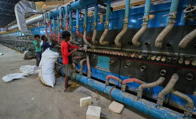 Workers perform maintenance on a machine at a shuttered ceramic factory in Morbi in the Indian state of Gujarat, Wednesday, April 8, 2026. (AP Photo/Ajit Solanki)