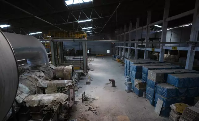 A worker sweeps the floor of a closed ceramics factory in Morbi,in the Indian state of Gujarat, Wednesday, April 8, 2026. (AP Photo/Ajit Solanki)
