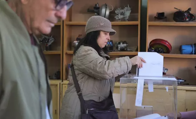People cast.their ballots at a polling station in Sofia, Bulgaria, Sunday, April 19, 2026, during early parliamentary elections. (AP Photo/Valentina Petrova)