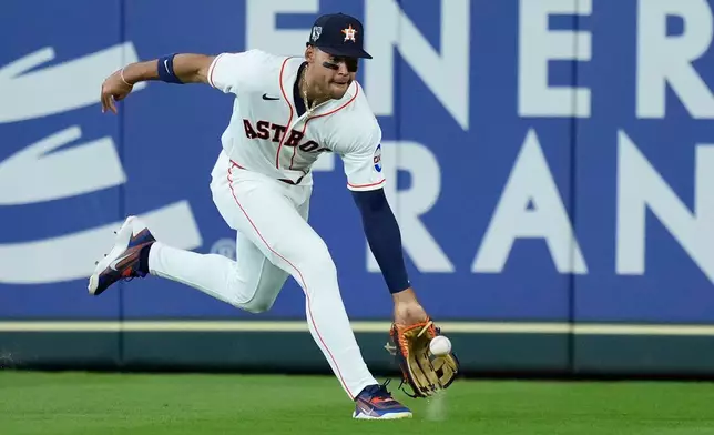 Houston Astros right fielder Cam Smith fields a base hit by Colorado Rockies' Mickey Moniak during the first inning of a baseball game Wednesday, April 15, 2026, in Houston. (AP Photo/Kevin M. Cox)