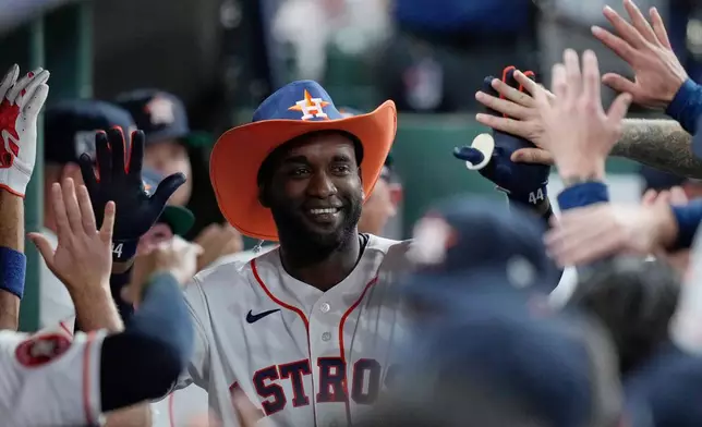 Houston Astros designated hitter Yordan Alvarez is congratulated in the dugout after hitting a solo home run during the third inning of a baseball game against the Colorado Rockies, Wednesday, April 15, 2026, in Houston. (AP Photo/Kevin M. Cox)