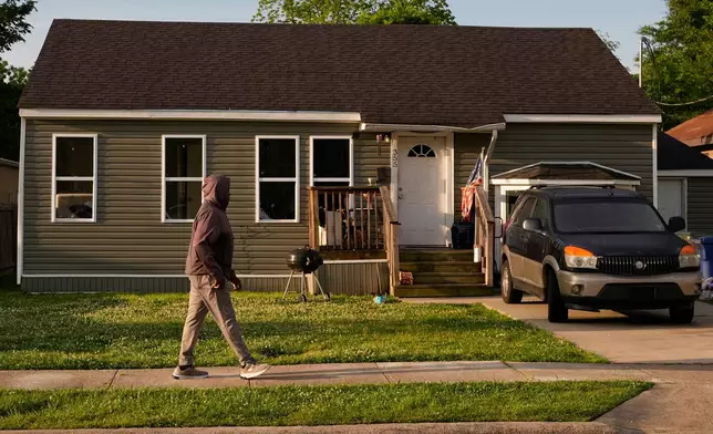 A person passes the home where a mass shooting occurred the day before in Shreveport, La., Monday, April 20, 2026. (AP Photo/Gerald Herbert)
