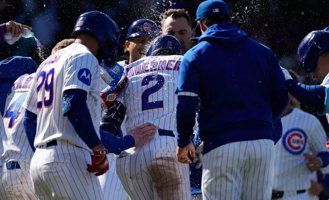 Chicago Cubs' Nico Hoerner (2) celebrates with teammates after hitting a sacrifice fly to New York Mets right fielder Tyrone Taylor during the 10th inning of a baseball game in Chicago, Sunday, April 19, 2026. (AP Photo/Nam Y. Huh)