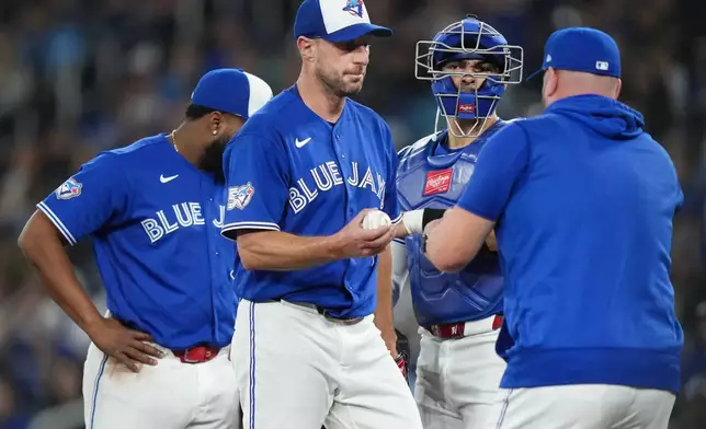 Toronto Blue Jays pitcher Max Scherzer, second from left, is pulled by manager John Schneider, right, during third-inning baseball game action against the Minnesota Twins in Toronto, Sunday, April 12, 2026. (Nathan Denette/The Canadian Press via AP)