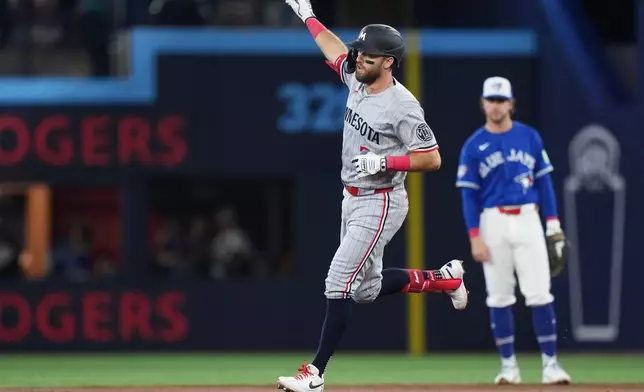 Minnesota Twins' Kody Clemens, foreground, rounds the bases after hitting a solo home run against the Toronto Blue Jays during third-inning baseball game action in Toronto, Sunday, April 12, 2026. (Nathan Denette/The Canadian Press via AP)