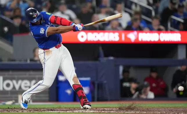 Toronto Blue Jays' Vladimir Guerrero Jr. hits a single against the Minnesota Twins during seventh-inning baseball game action in Toronto, Sunday, April 12, 2026. (Nathan Denette/The Canadian Press via AP)