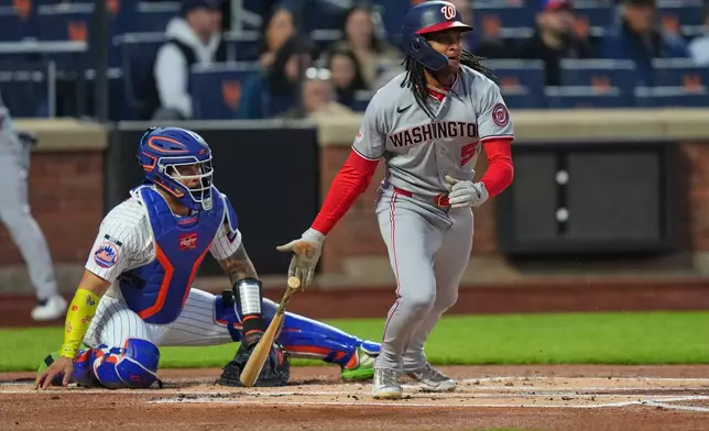 New York Mets catcher Francisco Alvarez, left, watches as Washington Nationals' CJ Abrams, right, follows through on a RBI single during the first inning of a baseball game Wednesday, April 29, 2026, in New York. (AP Photo/Frank Franklin II)