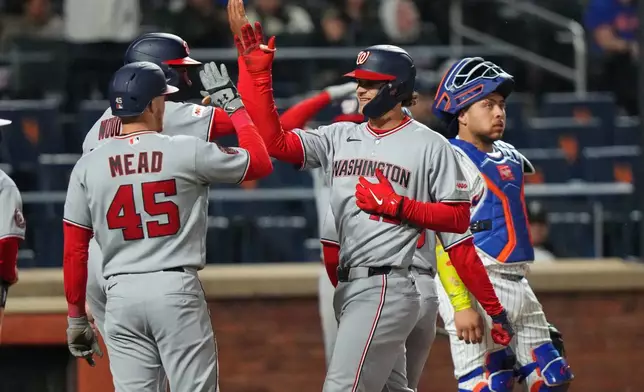 New York Mets catcher Francisco Alvarez, right, looks away as Washington Nationals' Brady House celebrates with Christian Scott, left, and James Wood after hitting a grand slam during the fourth inning of a baseball game Wednesday, April 29, 2026, in New York. (AP Photo/Frank Franklin II)