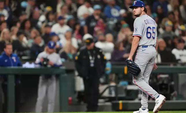 Texas Rangers relief pitcher Gavin Collyer walks back to the dugout after the fifth inning of a baseball game against the Seattle Mariners, Friday, April 17, 2026, in Seattle. (AP Photo/Lindsey Wasson)