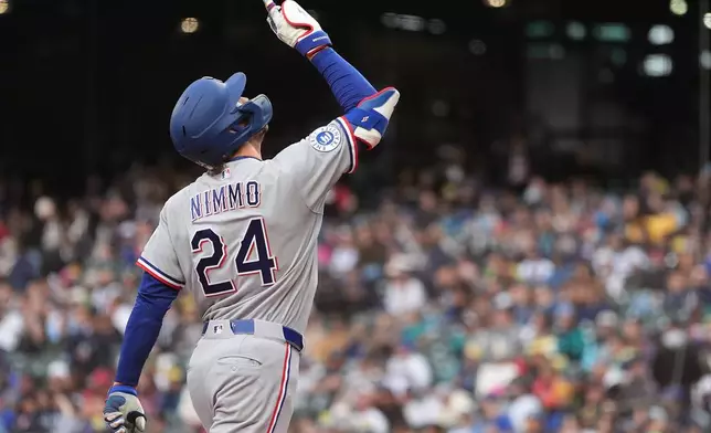 Texas Rangers' Brandon Nimmo points as he jogs home after hitting a solo home run against the Seattle Mariners during the first inning of a baseball game, Friday, April 17, 2026, in Seattle. (AP Photo/Lindsey Wasson)