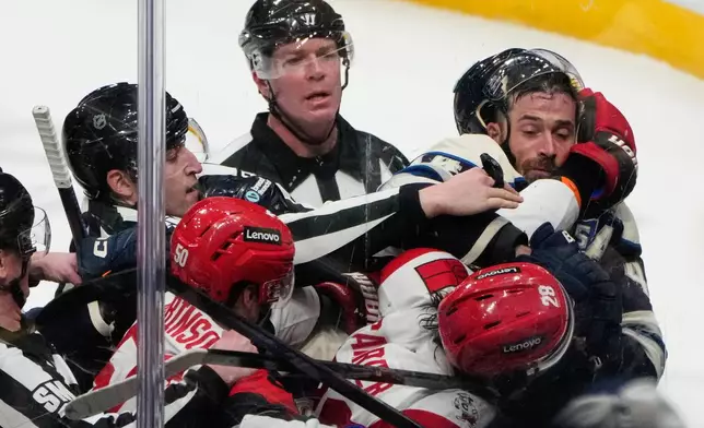 Officials separate Carolina Hurricanes left wing William Carrier (28) and defenseman Erik Gudbranson, right, in the second period of an NHL game in Columbus, Tuesday, March 31, 2026. (AP Photo/Sue Ogrocki)