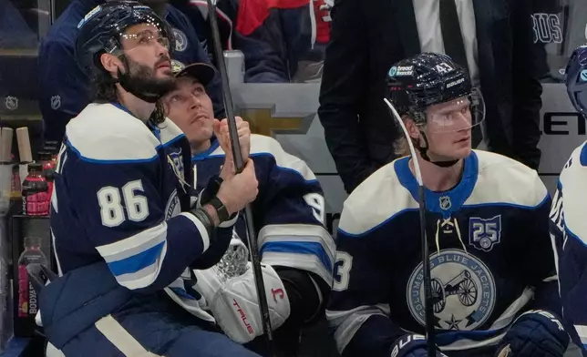 Columbus Blue Jackets right wing Kirill Marchenko (86), goaltender Elvis Merzlikins, center, and left wing Danton Heinen (43) watch the scoreboard as officials determine a shot bty Marchenko was a goal in the second period of an NHL game against the Carolina Hurricanes in Columbus, Tuesday, March 31, 2026. (AP Photo/Sue Ogrocki)