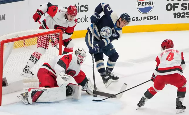 Carolina Hurricanes goaltender Brandon Bussi (32) blocks a shot by Columbus Blue Jackets left wing Mason Marchment (17) in the second period of an NHL game in Columbus, Tuesday, March 31, 2026. (AP Photo/Sue Ogrocki)